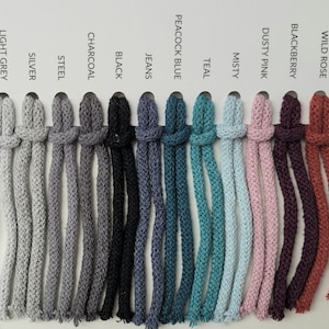 May include: A colour chart of 12 different colours of cotton cord. The colours are: Wild Rose, Blackberry, Dusty Pink, Misty, Teal, Peacock Blue, Jeans, Black, Charcoal, Steel, Silver, and Light Grey.