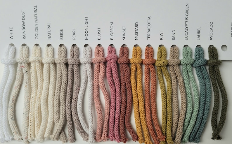 May include: A colour chart of 17 different colours of cotton cord. The colours are: White, Rainbow Dust, Golden Natural, Natural, Beige, Pearl, Moonlight, Blush, Blossom, Sunset, Mustard, Terracotta, Kiwi, Sand, Eucalyptus Green, Laurel, and Avocado.