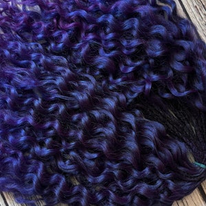 May include: A bundle of dark purple and blue curly synthetic hair extensions.