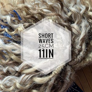 May include: Short wavy hair extensions in blonde and brown colors. The hair is 11 inches long and is shown in a bundle. The text "SHORT WAVES 25CM 11IN" is on a white hexagon.