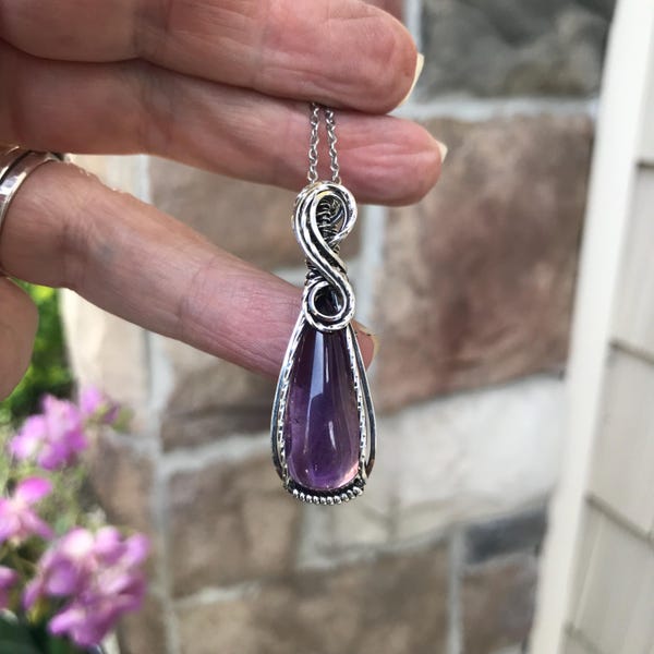Collana con ametista avvolta in filo d'argento e ciondolo artigianale in cristallo di quarzo viola.