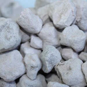 Puede incluir: Primer plano de un mont&oacute;n de peque&ntilde;as piedras blancas de forma irregular. Las piedras tienen una superficie rugosa y texturizada.