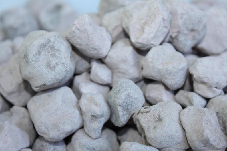 Puede incluir: Primer plano de un mont&oacute;n de peque&ntilde;as piedras blancas de forma irregular. Las piedras tienen una superficie rugosa y texturizada.