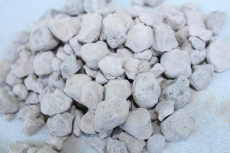 Puede incluir: Un mont&oacute;n de peque&ntilde;as piedras blancas de forma irregular. Las piedras son lisas y tienen una textura ligeramente rugosa.