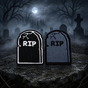 May include: Two embroidered patches shaped like tombstones, one black and one gray, each with the letters "RIP" in white. The patches have a white border and are set against a spooky, moonlit graveyard scene.