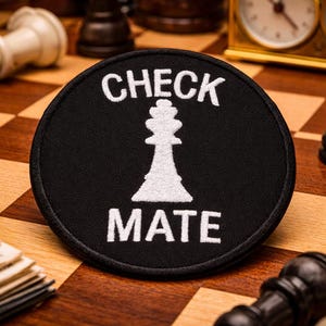 May include: A white ceramic mug with a black handle and the text "But First, Coffee" in a bold, black font. The mug is set against a blurred background, suggesting a cozy setting.