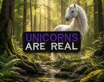 May include: A patch with the text "UNICORNS ARE REAL" in white and purple on a black background. A white unicorn with a long mane and horn stands in a forest with a stream.