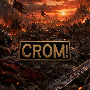 Puede incluir: Un parche rectangular negro con la palabra "CROM!" bordada en hilo dorado. El parche se encuentra sobre un fondo de campo de batalla con una puesta de sol ardiente, banderas y armas medievales.