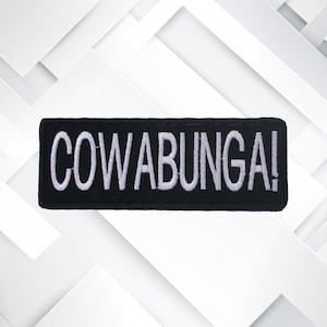 Peut inclure: &Eacute;cusson brod&eacute; noir avec inscription blanche "COWABUNGA!"