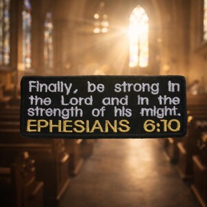 May include: Black rectangular patch with white text that reads "Finally, be strong in the Lord and in the strength of his might. EPHESIANS 6:10." The text is embroidered in white and gold thread.