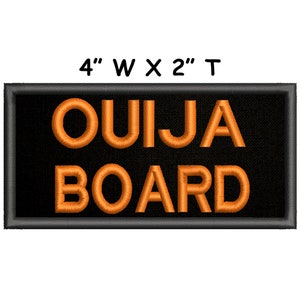 Puede incluir: Un parche bordado negro con texto naranja que dice "OUIJA BOARD". El parche mide 10 cm de ancho por 5 cm de alto.