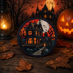 Puede incluir: Un parche redondo con un diseño de casa embrujada, una luna llena y murciélagos. La imagen incluye una calabaza tallada, una linterna encendida y hojas de otoño, evocando Halloween.
