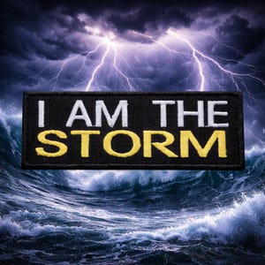May include: Black rectangular patch with the text "I AM THE STORM" in white and yellow lettering. The patch is set against a background of a stormy sea with lightning flashing in the sky.