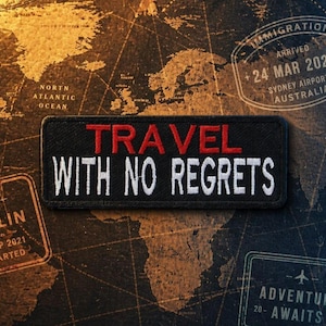 May include: A black rectangular patch with the words "TRAVEL WITH NO REGRETS" in red and white lettering. The patch is set against a map background with travel-themed stamps and text.