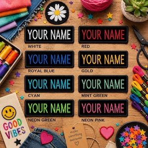 May include: A collection of personalized name patches in various colors, including white, red, royal blue, gold, cyan, mint green, neon green, and neon pink. Each patch features the text "YOUR NAME" in a contrasting color on a black background. The patches are surrounded by craft supplies.