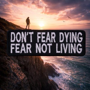 May include: Black rectangular patch with white embroidered text: "DON'T FEAR DYING FEAR NOT LIVING." The patch is set against a scenic background of a person standing on a cliff overlooking the ocean at sunset.