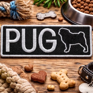 May include: A black patch with the word "PUG" in white lettering and a silhouette of a pug dog. The image also includes dog treats, a tennis ball, a dog collar, and a bowl of dog food, all arranged on a wooden surface.