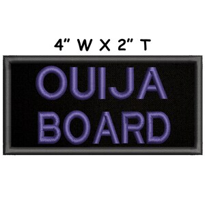 Puede incluir: Un parche bordado negro con un texto "OUIJA BOARD" en morado. El parche mide 10 cm de ancho por 5 cm de alto.