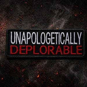Puede incluir: Un parche rectangular negro con las palabras "UNAPOLOGETICALLY DEPLORABLE" bordadas en blanco y rojo. El parche se encuentra sobre un fondo oscuro y texturizado con acentos de fuego naranja.