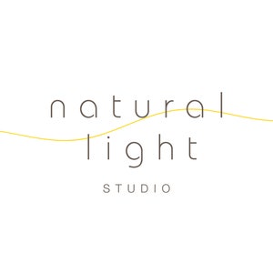 May include: A logo for a photography studio called "natural light studio". The logo features the words "natural light" in a simple, sans-serif font. The word "natural" is above the word "light", and a thin yellow line curves between the two words.