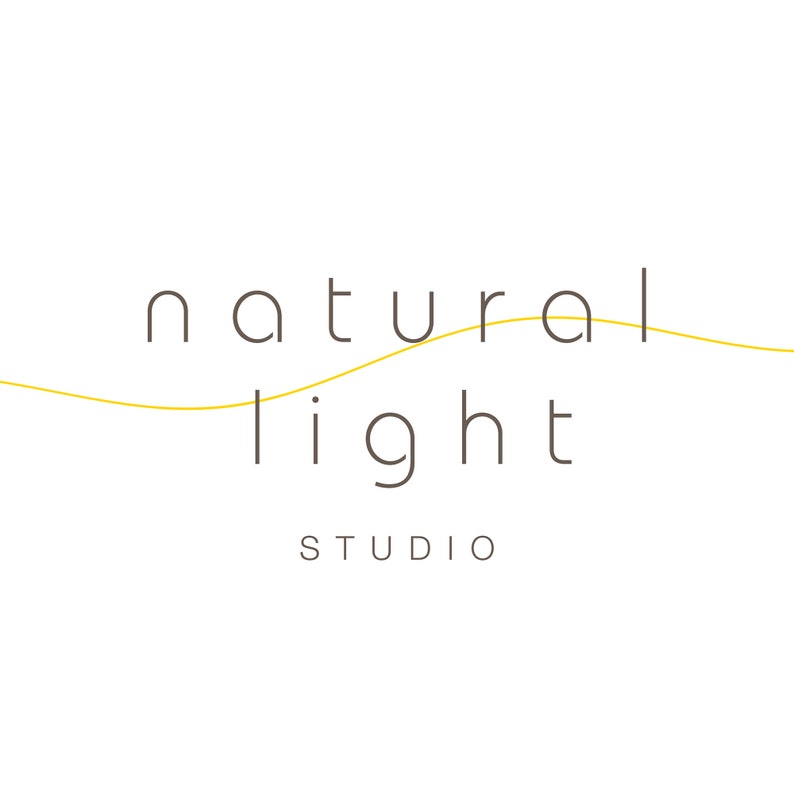 May include: A logo for a photography studio called "natural light studio". The logo features the words "natural light" in a simple, sans-serif font. The word "natural" is above the word "light", and a thin yellow line curves between the two words.