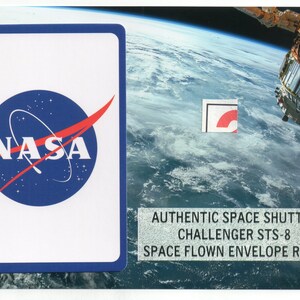 May include: An authentic space flown envelope relic featuring the NASA logo on a white card with a blue border. The image includes the text "AUTHENTIC SPACE SHUTTLE CHALLENGER STS-8 SPACE FLOWN ENVELOPE RELIC."
