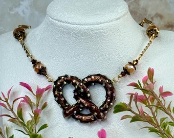 Bedazzled Pretzel Pendant Necklace Peach and Bronze Beads and embellished extender chain