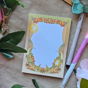 May include: A decorative notepad featuring a floral and butterfly design. The notepad has a light blue background and a white border. The notepad is ideal for jotting down notes, ideas, or to-do lists.