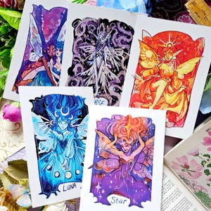 May include: Set of five watercolour illustrations featuring fairy-like figures with wings. Each illustration has a different colour scheme and features a different celestial theme: Luna, Star, Sun, Moon, and a figure with a star on its head.