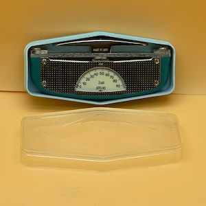 Könnte beinhalten: Ein blauer und silberner Winkelmesser mit einem transparenten Kunststoffgehäuse. Der Winkelmesser hat ein Zifferblatt, das von 0 bis 90 Grad reicht und mit "2-M1 APT-90" beschriftet ist.