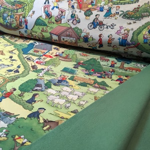 May include: A colourful illustration of a busy park scene with people, animals, and buildings. The illustration is printed on a green fabric.