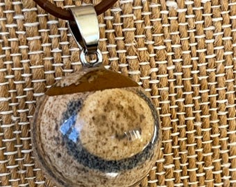 Round DESERT JASPER stone PENDANT on matching brown leather cord necklace.  Wooden bead closures. Adjustable length from choker to 17 inches