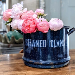 May include: A white ceramic mug with a black handle and the text "But First, Coffee" in a handwritten style. The mug is on a white surface. The mug is approximately 4 inches tall.