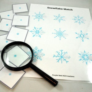 May include: A snowflake matching game with a magnifying glass. The game includes nine small cards with snowflakes and nine larger cards with snowflakes. The text "Snowflake Match" is printed at the top of the page. The text "Purple Nest Kid Creations" is printed at the bottom of the page.