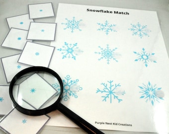 May include: A snowflake matching game with a magnifying glass. The game includes nine small cards with snowflakes and nine larger cards with snowflakes. The text "Snowflake Match" is printed at the top of the page. The text "Purple Nest Kid Creations" is printed at the bottom of the page.