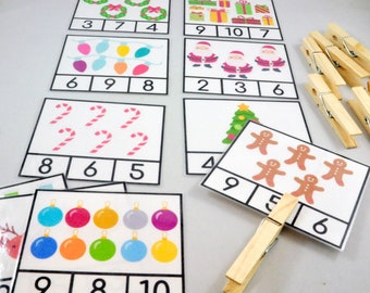 May include: A set of Christmas-themed counting cards with images of ornaments, candy canes, Santa Claus, Christmas trees, and gingerbread men. Each card has a number grid with numbers 2, 3, 4, 5, 6, 7, 8, 9, and 10. The cards are designed for children to learn counting and number recognition.
