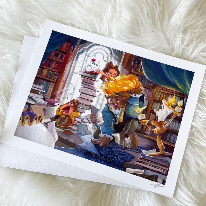 Peut inclure: Une impression avec une illustration color&eacute;e des personnages de La Belle et la B&ecirc;te. Belle est sur le dos de la B&ecirc;te, entour&eacute;e de Lumi&egrave;re, Big Ben et d'une pile de livres. L'&oelig;uvre est situ&eacute;e dans une biblioth&egrave;que avec une rose sous cloche.