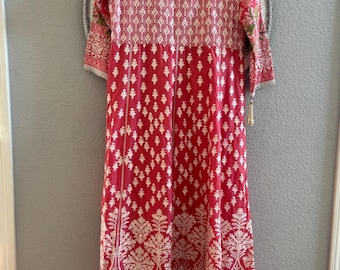 May include: A red and white patterned dress with long sleeves. The dress features a detailed white floral design on a red background. The sleeves and hem are trimmed with a delicate lace.