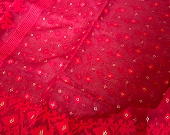 May include: A vibrant red textile with intricate patterns. The fabric features a repeating diamond and floral design, with a detailed border. The material appears sheer and lightweight, with a subtle sheen. The overall aesthetic is elegant and eye-catching.