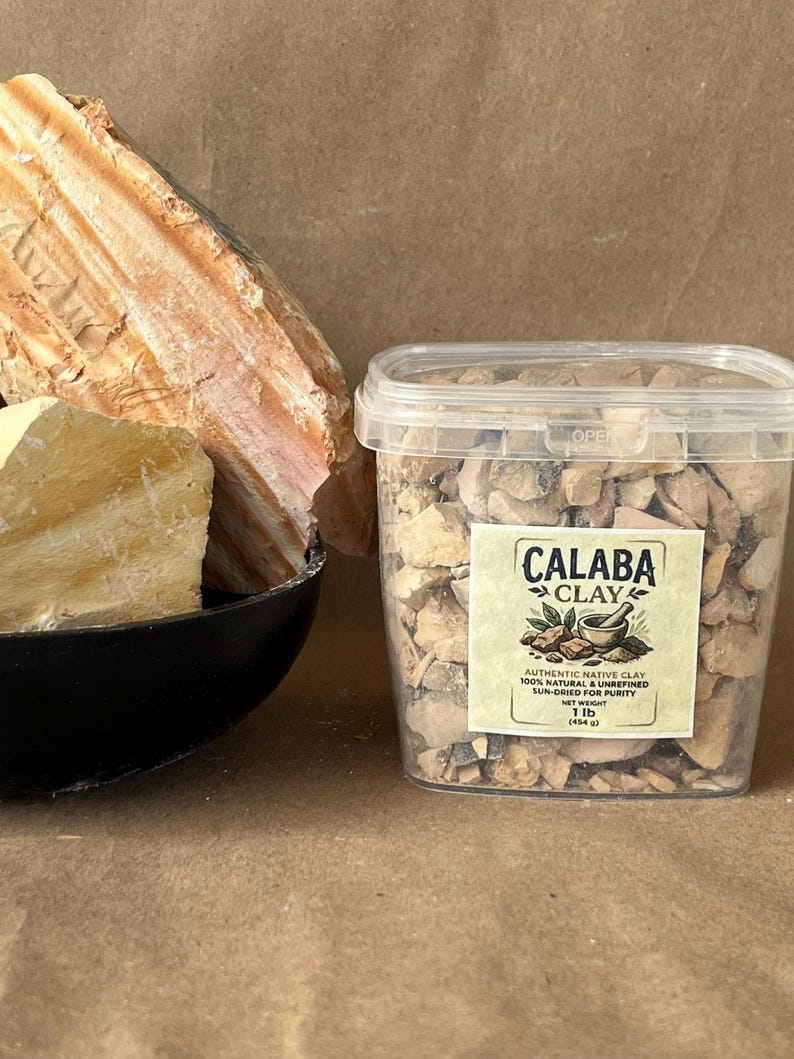 Puede incluir: Un recipiente de pl&aacute;stico transparente lleno de peque&ntilde;os trozos irregulares de arcilla Calaba, con una etiqueta que dice Calaba Clay, 100% natural & unrefined, sun-dried for purity, net weight 1 lb (454 g), junto a un cuenco negro con trozos grandes.
