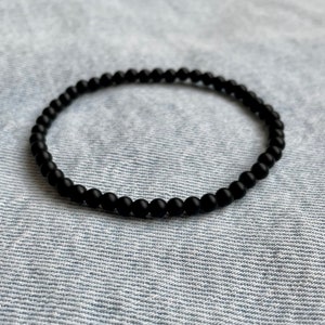 May include: A black beaded bracelet with a simple design.