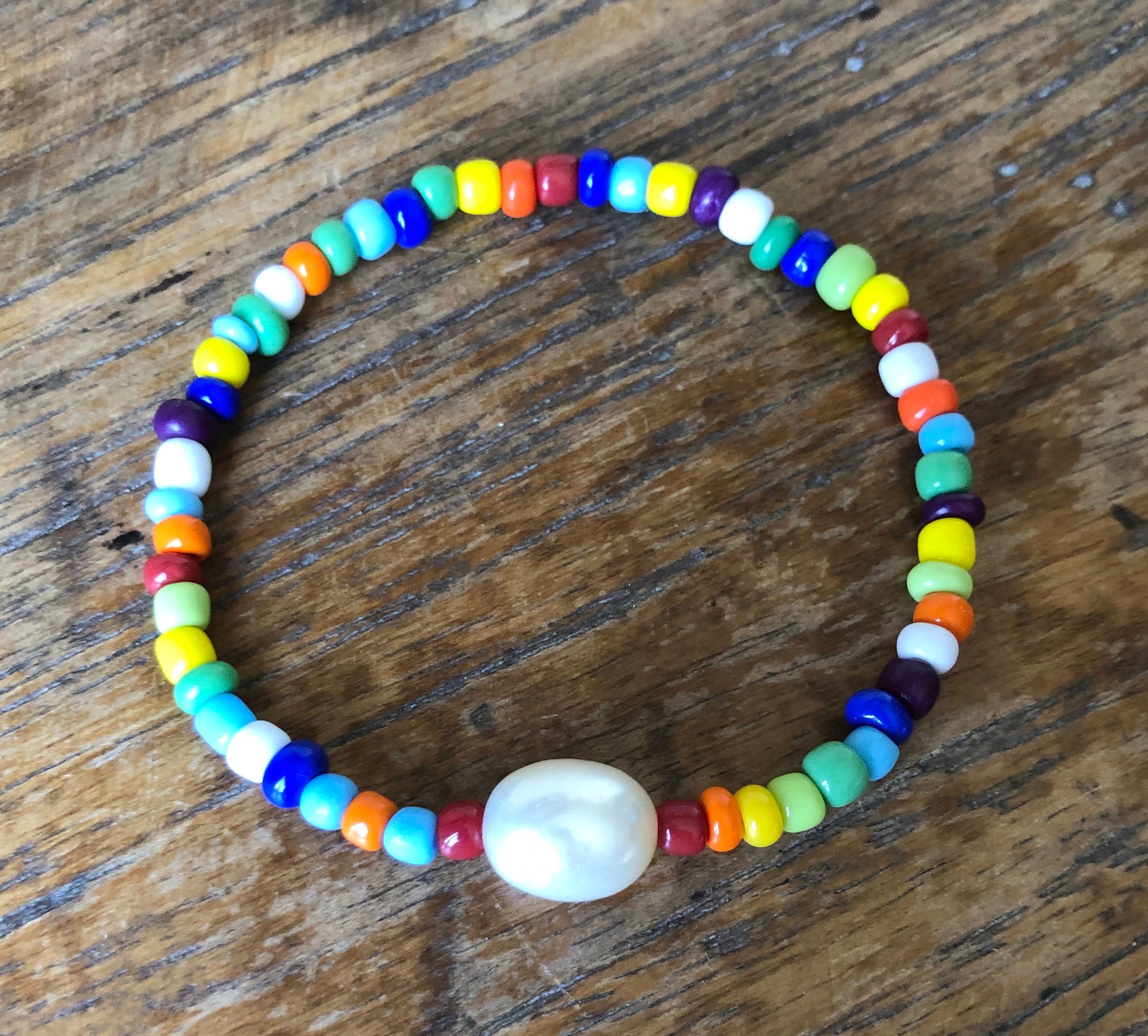Bracelet Petit CD Métal finition dorée et perle en résine rose nacrée
