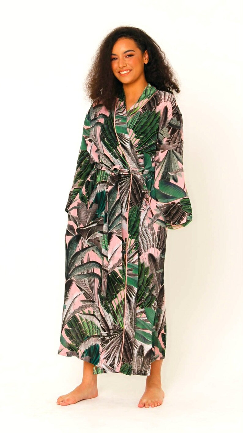 Puede incluir: Una larga bata de color rosa y verde con estampado floral y un cintur&oacute;n para atar. La bata tiene un ribete verde y mangas largas.
