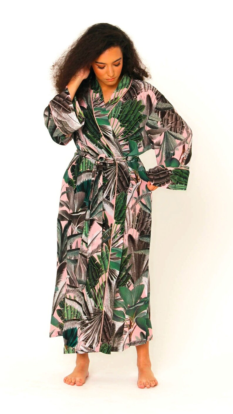 Puede incluir: Una bata de color rosa y verde con estampado floral, mangas largas y cintur&oacute;n de atar.