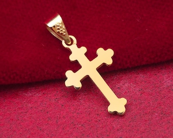 May include: A gold-colored pendant in the shape of a cross. The cross has decorative edges and a loop for a chain. The pendant is displayed against a red background. The logo "DIMOS" is visible in the lower right corner.