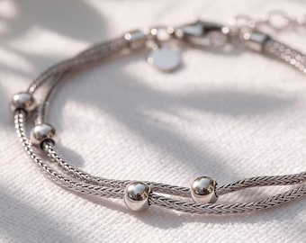 Armband van sterling zilver met dubbele schakels in de vorm van een vossenstaartketting en gladde zilveren kralen.