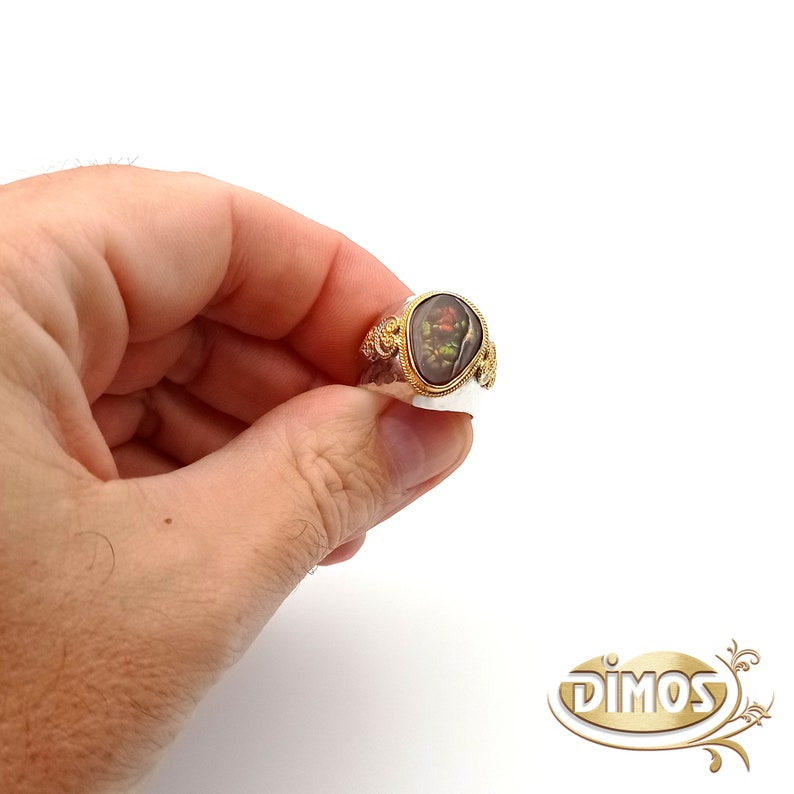 May include: A gold ring with a brown and green gemstone set in a decorative gold setting.