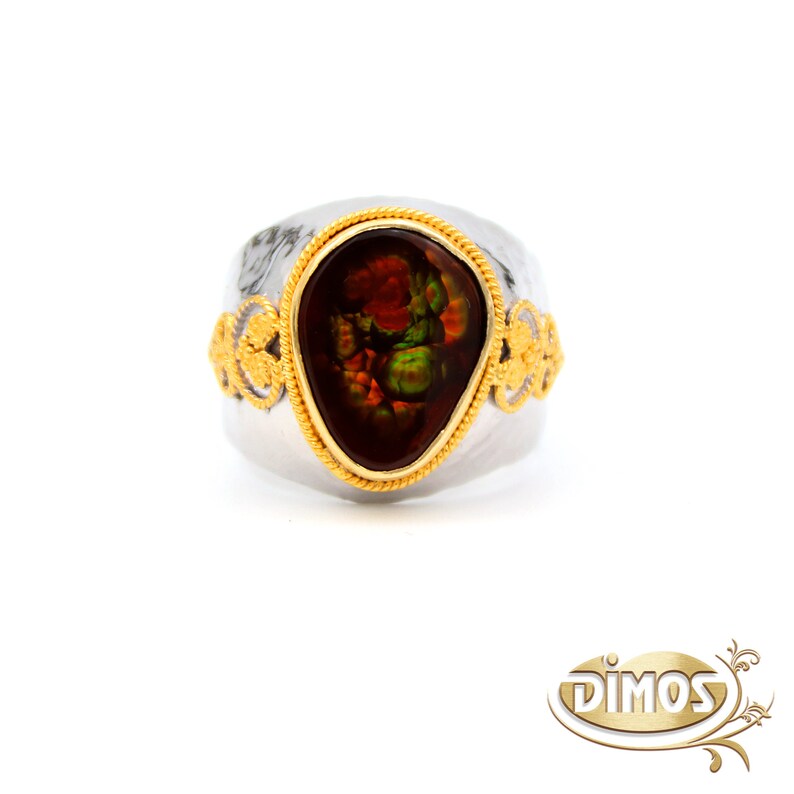 May include: A silver ring with a gold band and a large, teardrop-shaped, multi-coloured agate gemstone.