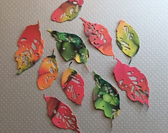 May include: Ten paper leaves in various shades of red, orange, green, and yellow. The leaves have a cut-out design and are perfect for crafting projects.