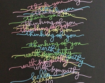 May include: A black background with colorful cursive words written in different colors. The words include "welcome baby", "thank you", "thinking of you", "with sympathy", and "hello".